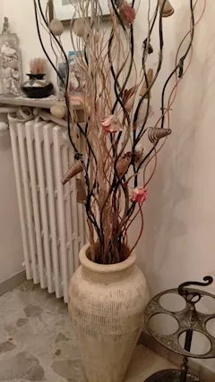 Vaso con fiori finti e radici di mangrovia