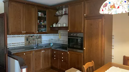 Cucina completa in legno massello con tavolo, sedie e panca