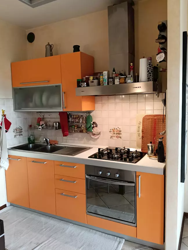 Cucina completa di elettrodomestici, colore arancio, in buone condizioni